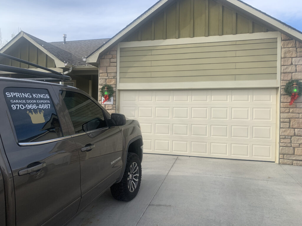 traditional garage door with no windows and the Spring Kings service truck